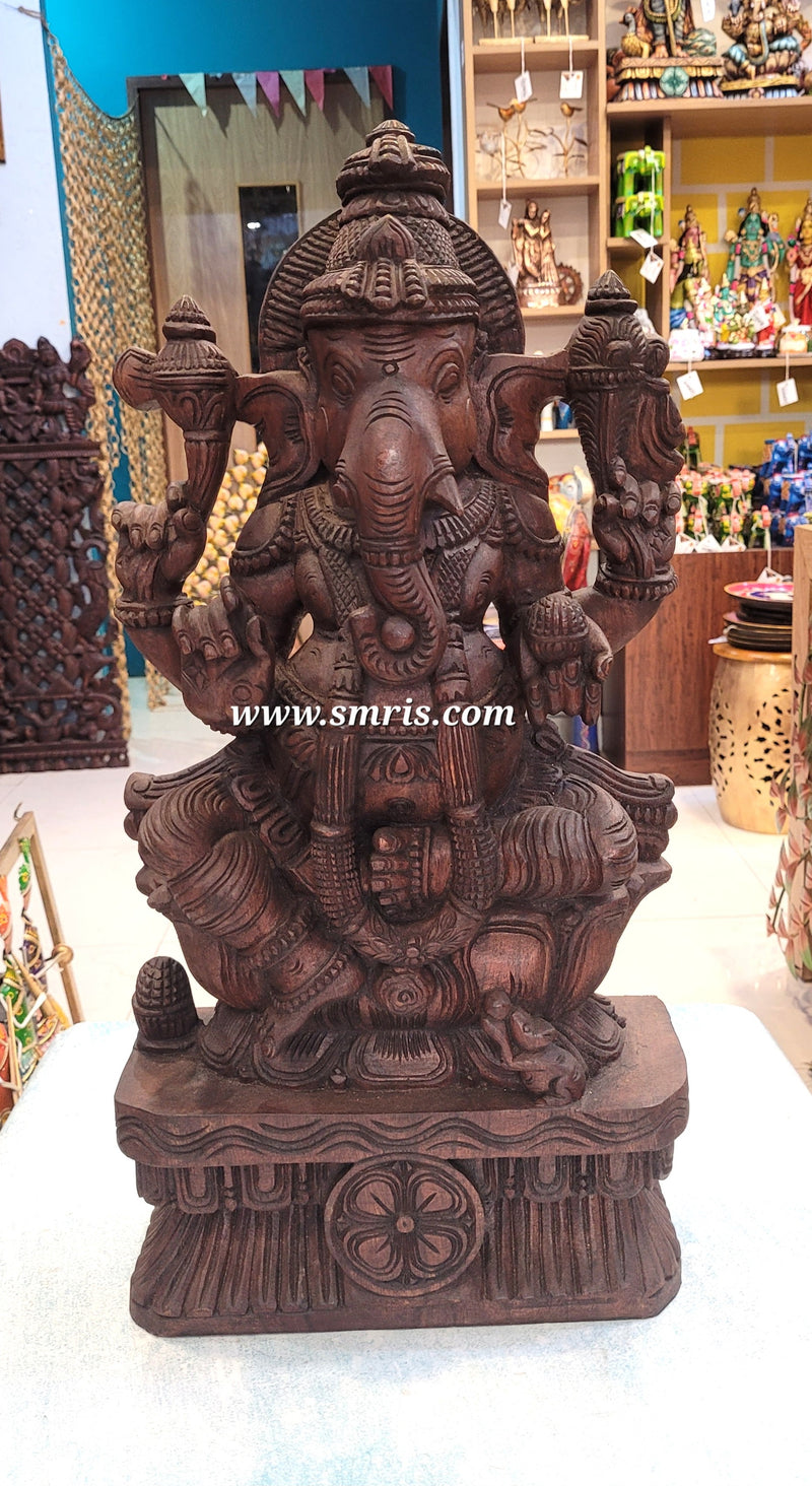 Wooden statue of a deity with intricate carvings in a store setting.