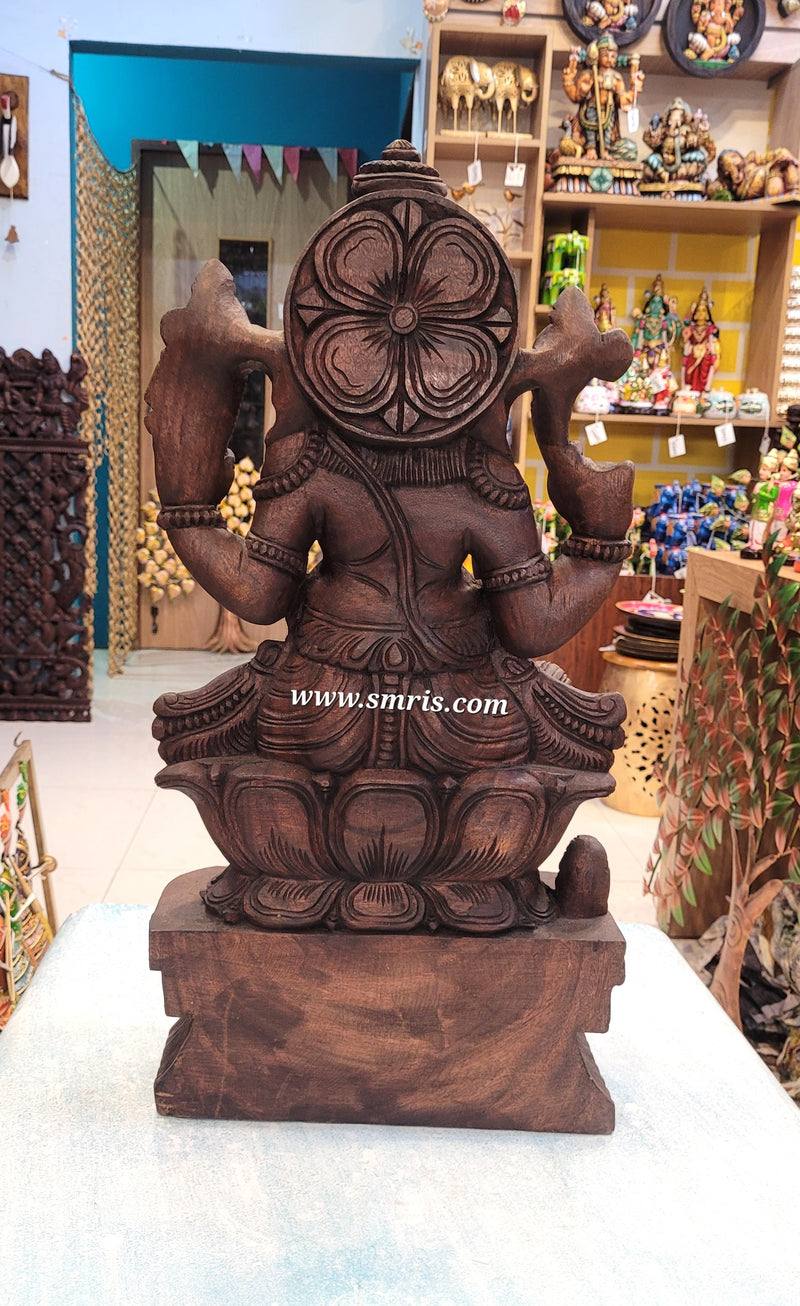 Brown stone sculpture of a deity in a store setting